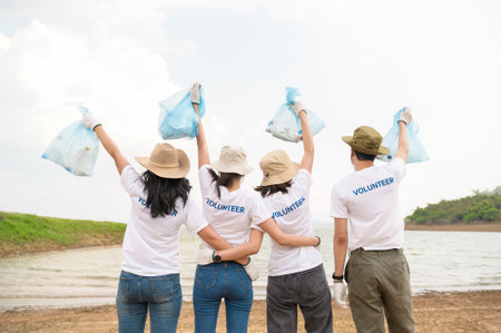 Volunteers from the Asian youth community using rubbish bags cleaning  up nature parの写真素材
