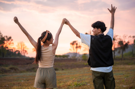Silhouette of couple over golden sunset background feeling happinessの写真素材