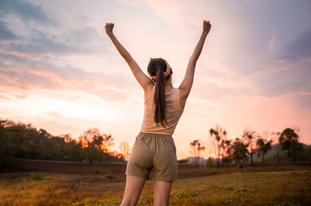 Silhouette woman over golden sunset background feeling happy successful in her life