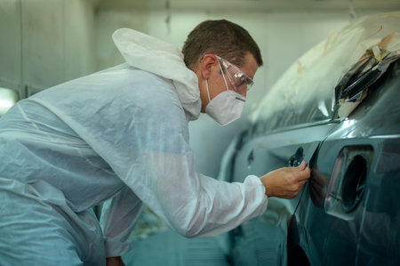 caucasian man is checking color painting in repair mechanic painting shopの写真素材