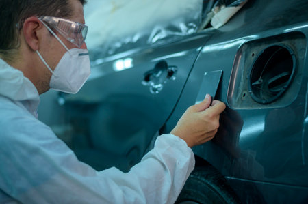 caucasian man is checking color painting in repair mechanic painting shopの写真素材