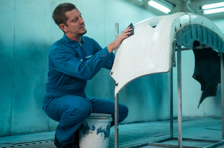 Caucasian man is cleaning car parts before spraying color in repair mechanic painting shopの写真素材