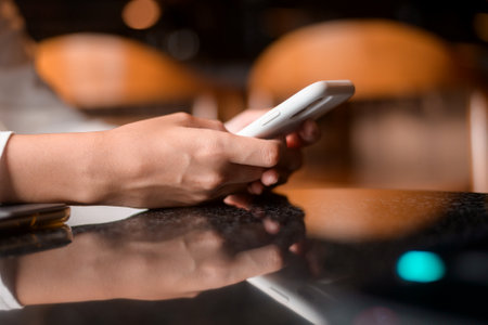 Close up woman hand using smart phone in cafe backgroundの写真素材