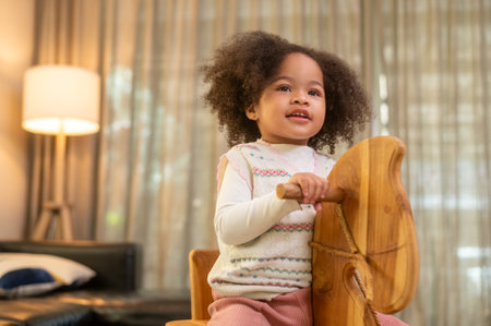 Happy African American girl playing in living room at homeの写真素材