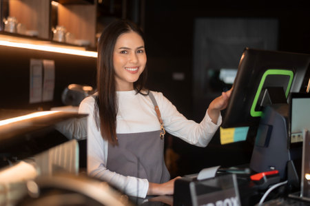 A young woman cashier working in modern coffee shopの写真素材