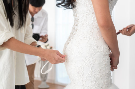 Close up of tying bow on elegant White bridal wedding dressの写真素材