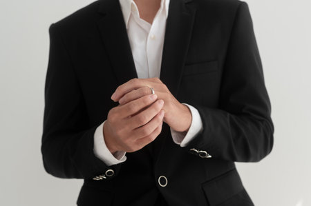 Portrait of young handsome groom in suit, preparing for wedding ceremony
