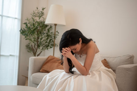 Sad and worried bride crying and arguing with groom in wedding dayの写真素材