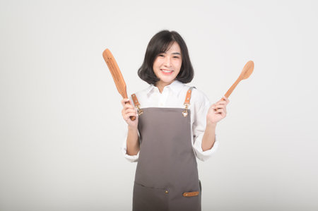 Asian smiling female entrepreneur or barista wearing an apron over white background, concept small businessの写真素材