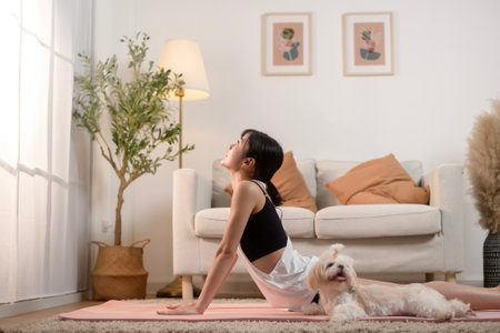 Young woman in sportswear doing meditation practice and yoga with cute dog in living room, healthy lifestyle, Mental health concept.の写真素材
