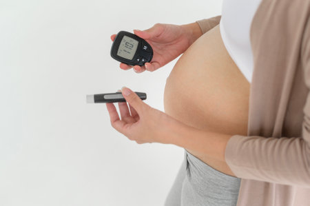 Pregnant woman checking blood sugar level by using Digital Glucose meter, health care, medicine, diabetes, glycemia conceptの写真素材