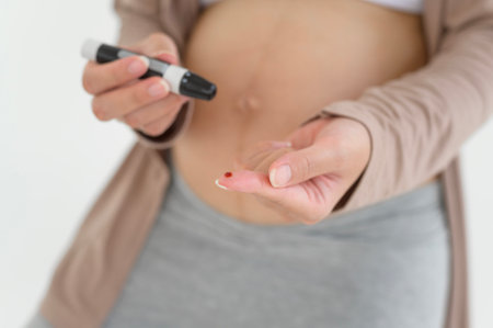 Pregnant woman checking blood sugar level by using Digital Glucose meter, health care, medicine, diabetes, glycemia conceptの写真素材