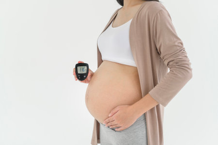 Pregnant woman checking blood sugar level by using Digital Glucose meter, health care, medicine, diabetes, glycemia conceptの写真素材