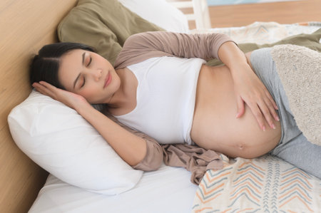 Pregnant woman sleeping on the bed, pregnancy and expectation conceptの写真素材