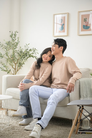 Portrait of young asian couple sitting in living room at home