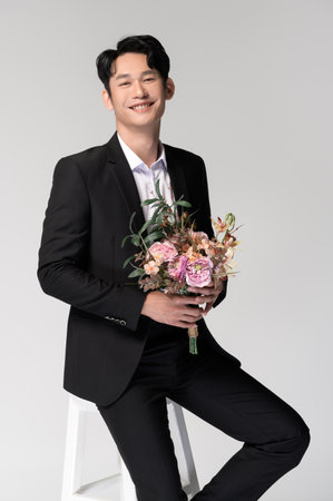 Groom holding wedding bouquet over white backgroundの写真素材