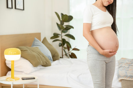 Beautiful asian pregnant woman expecting baby and touching her bellyの写真素材