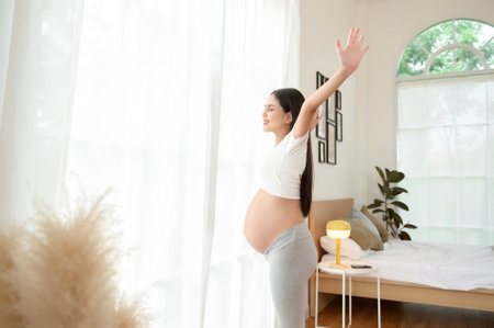 Happy smiling pregnant woman in her bedroom at homeの写真素材