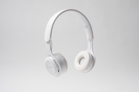 Sleek white headphones rest in mid-air, showcasing their minimalist design and comfort.の写真素材