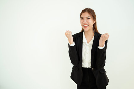 A confident woman in a black business suit poses with crossed arms and a smile.の写真素材