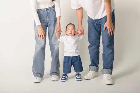 A happy family of three enjoys a playful moment in a studio setting, showcasing their love.の写真素材