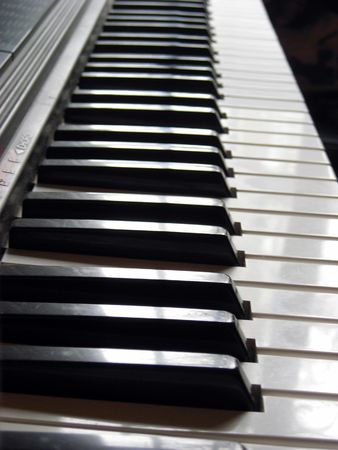 Black and white keys of an electronic organ keyboard at sun light.の写真素材