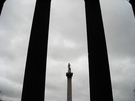 View of the Nelson statue at Trafalgar Square between the entrance columns of the National Galleryの写真素材
