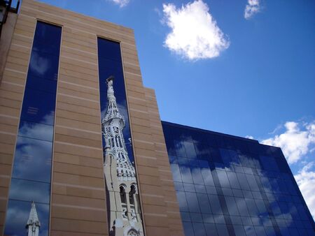 Reflection of a church tower on an office building on a sunny afternoon in Madrid.の写真素材