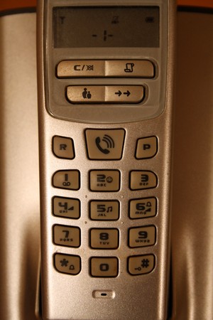 Digital phone over its charging baseの写真素材