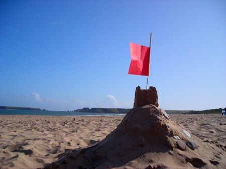 A sand castle on South Beach at Tenby with Caldey Island in the distance.の写真素材