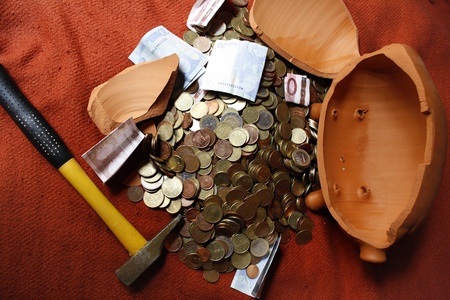 A broken piggybank containing some savings.