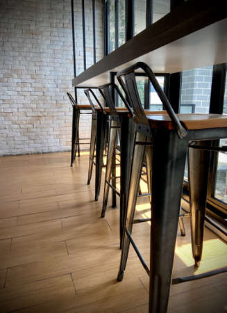 Row of log leng standing chair, interior design at the counter of lobby for guest to wait with natural light from the sun.の写真素材