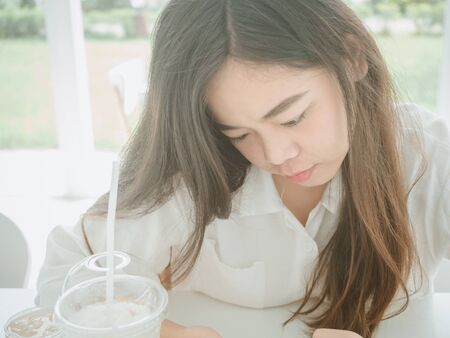Happiness concept from Close up portrait of cheerful young Asian woman smiling and relaxing in coffee shop.の写真素材