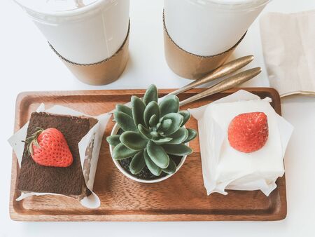 beverages and desserts concept from chocolate cake topping with fresh strawberry and drinks placed...