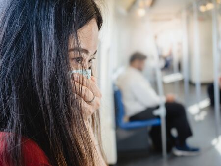 asian woman wearing protective mask against virus and air pollution in public transport.