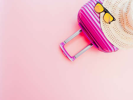 summer travel concept from suitcase with summer accessories on pastel pink background.の写真素材