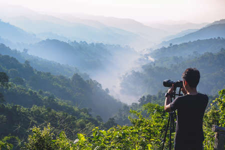 cameraman enjoying the nature view of hills and mountain are complex in the morning sunrise, at Mae Wong National park, Kamphaeng Phet, Thailand.の写真素材