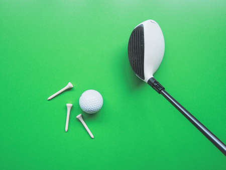 Golf equipment flat lay on green background. Top view
