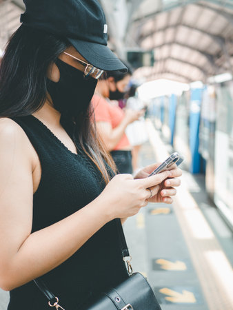 close-up woman wear protective mask and using smartphone in public transport.の写真素材