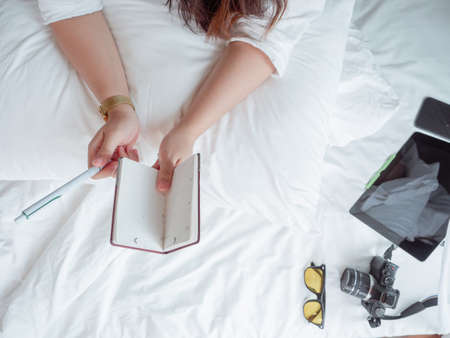 casual business concept from hands of woman working with the tablet at bedroom on the bed.
