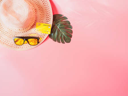 summer accessories concept from credit card and summer collection on pastel red background.の写真素材