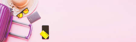summer travel concept from credit card and suitcase with summer collection on pink background. web...