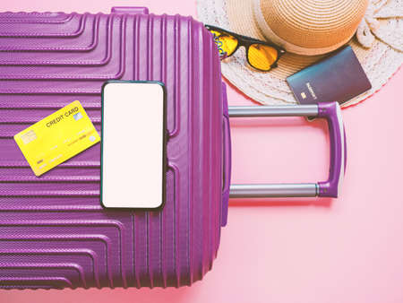 summer travel concept from credit card and suitcase with summer collection on pink background.の写真素材