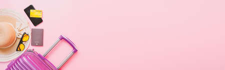 summer travel concept from credit card and suitcase with summer collection on pink background. web banner size.の写真素材