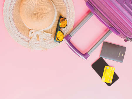 summer travel concept from credit card and suitcase with summer collection on pink background.の写真素材