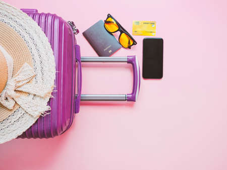 summer travel concept from credit card and suitcase with summer collection on pink background.の写真素材
