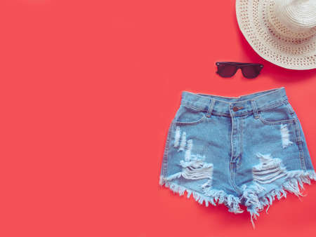 Summer accessories and Women's Clothing concept from bikini, sunglasses eyewear, straw hat, sunscreen and lipstick flat lay on green and red background pastel color for advertising selling products.の写真素材