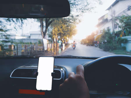 Blank empty screen smartphone on holder in car use for Navigation or GPS. Car interior view.