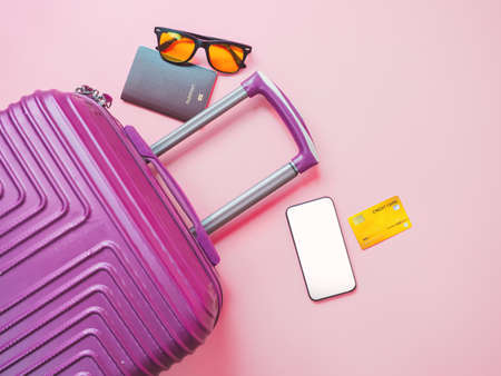 summer travel concept from credit card and suitcase with summer collection on pink background.の写真素材