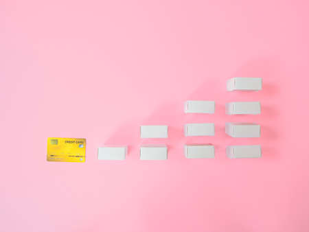 Marketing strategy or loan concepts from credit card and product box on pink background. Top view